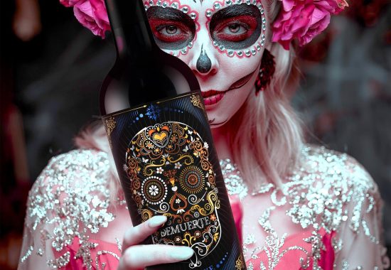 Gorgeous Calavera Catrina in a festive rich dress and headdress stands in the castle with a candle in her hand. Sugar skull girl. Day of The Dead. Halloween. Dia de los Muertos. Santa Muerte.